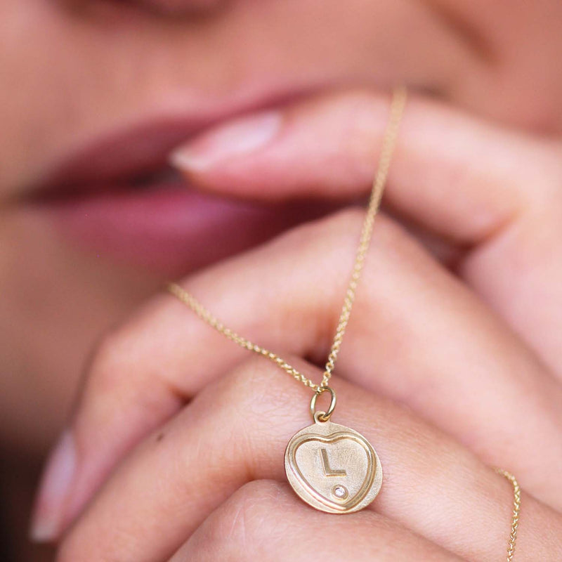 An example of the Love Hearts Initial Charm worn as a pendant by a model