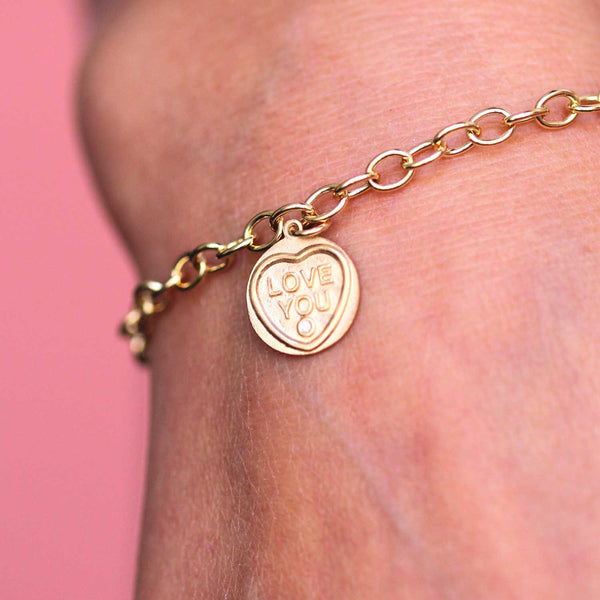 a love hearts 18ct gold personalised charm featured on a charm bracelet