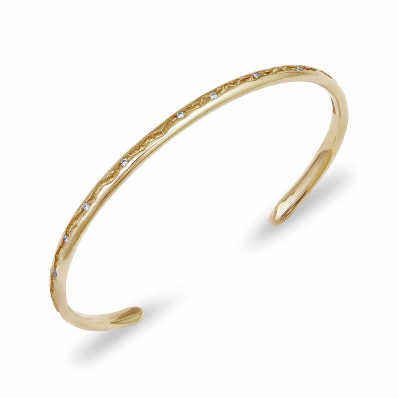 A simple gold bangle in a torque bangle design side view