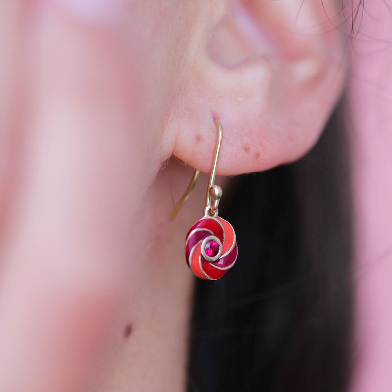 Rock Candy Bespoke Earrings with a spiral motif in yellow gold , enamel and ruby worn on a model